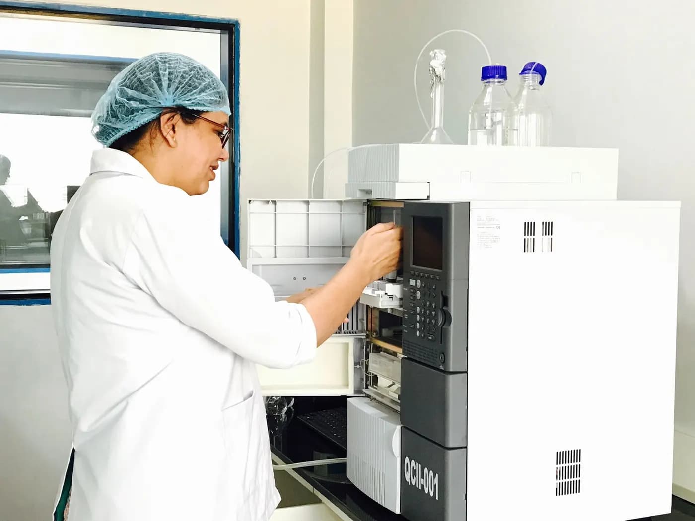 Scientist operating an analytical chemistry instrument in a laboratory